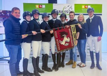 Nahmen die Wanderstandarte der Stadt Münster stolz entgegen (v. li.): Springtrainer Denis Huser-Geßmann, Sinia Teufel, Britta Knaup, Lara Könemann, Emily Bögel, Anna-Giulia Savic, Dressurtrainer Tim Scheunemann, Sophie Holkenbrink (Dressur) und Laurin Hofmann. (Foto: AGRAVIS Raiffeisen AG)